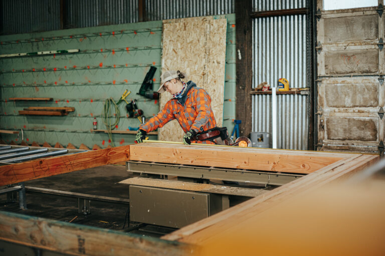 Woman measuring prefab wall panel