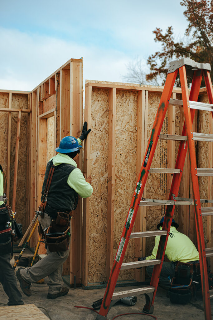 Builders standing a wall